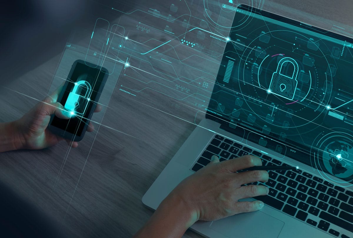 A person uses a smartphone and a laptop, both displaying digital padlock icons on their screens, symbolizing cybersecurity and data protection with a futuristic digital interface overlay.