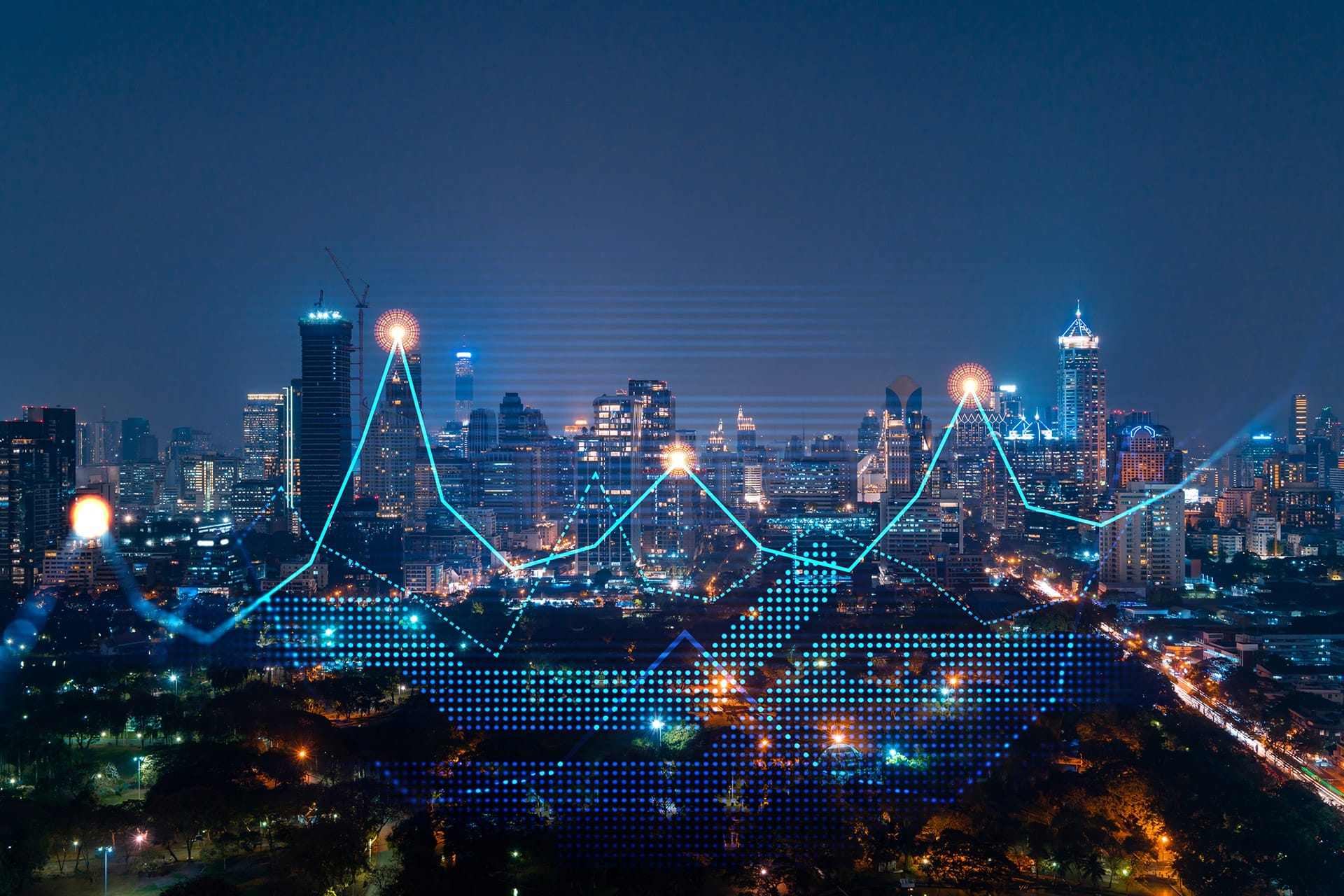City skyline at night with illuminated skyscrapers. A glowing digital graph with points and lines is superimposed, symbolizing data, finance, or technology trends over the urban landscape.