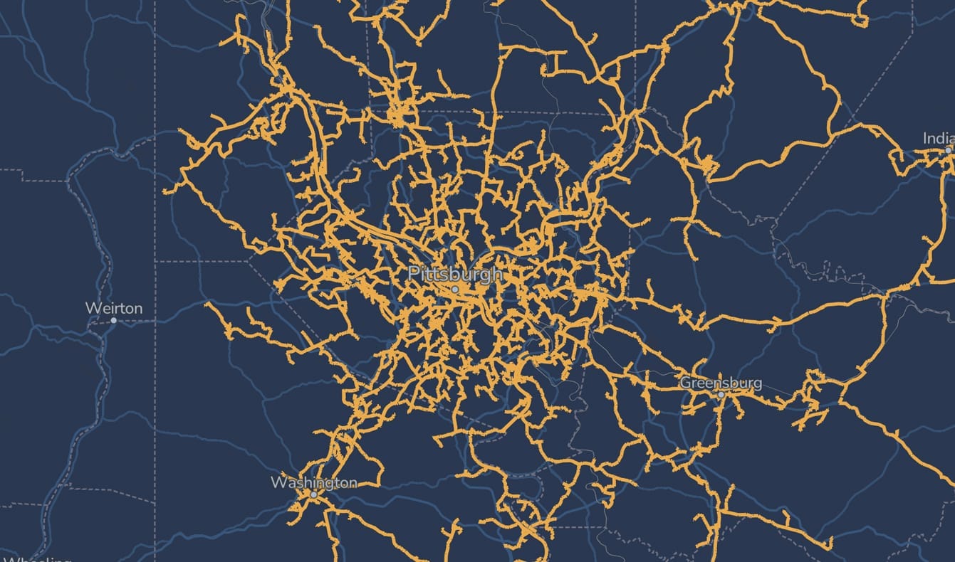 A dark blue map centered on Pittsburgh, displaying a dense network of orange lines radiating outward, representing roads or transportation routes extending to nearby cities like Weirton, Greensburg, and Washington.